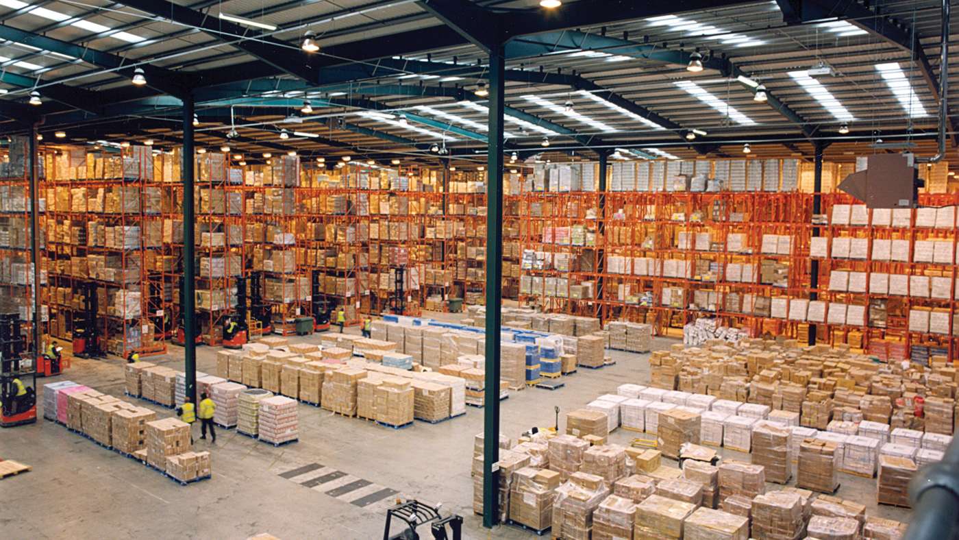 A distribution warehouse with pallets of boxes stacked along its aisles