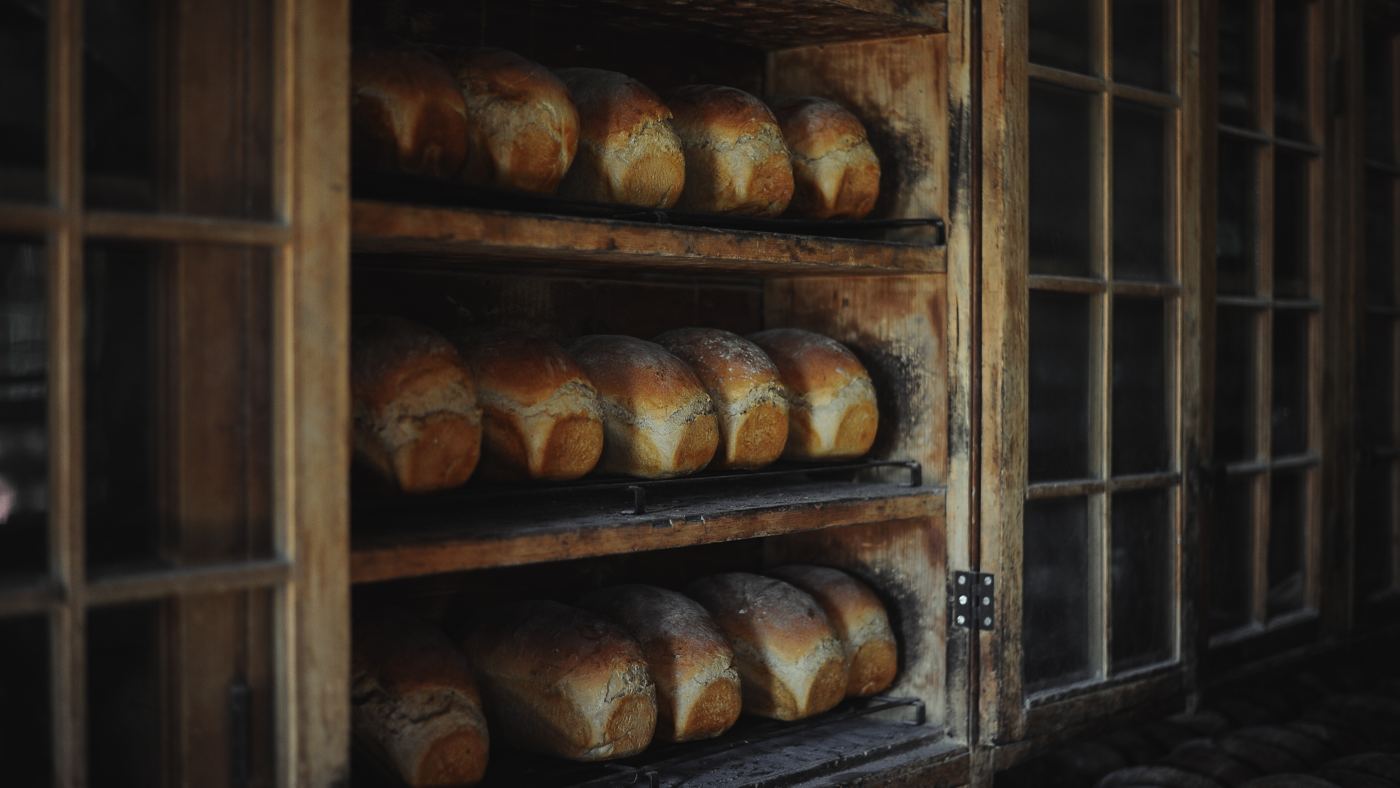 Loaves of bread cooling on a bakery rack